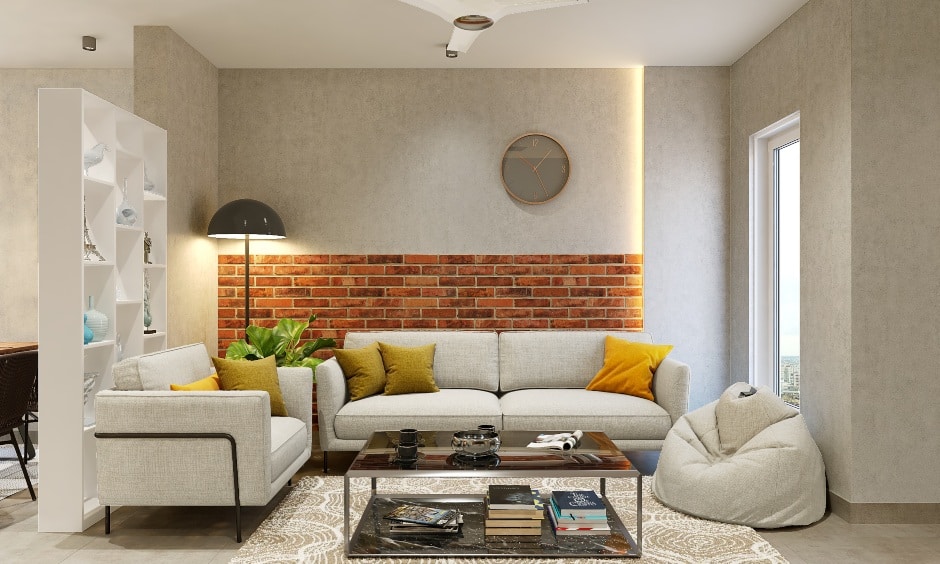 The living area features sandstone wallpaper and brick cladding walls, as well as a 3 Seater sofa with a center table and a bean bag for additional sitting.