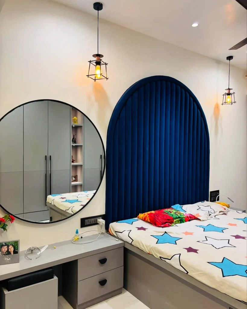 Kids bedroom with royal blue arched velvet headboard, star bedding, round mirror vanity, and grey modular storage